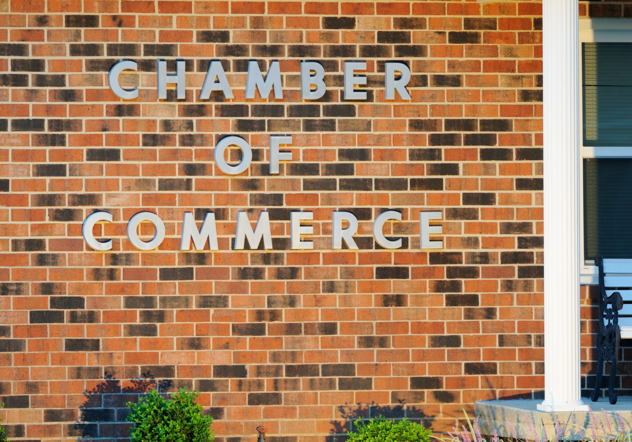 "Illuminated chamber of commerce sign on building, horizontal."